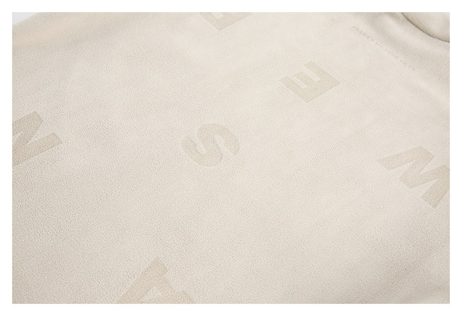 Close-up of cream loop-textured fabric with faint tonal geometric motifs.