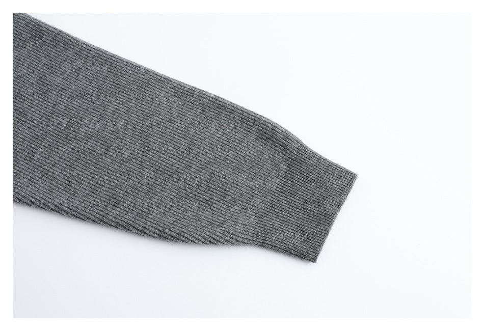 Close-up of the gray cardigan's ribbed sleeve and fitted cuff.