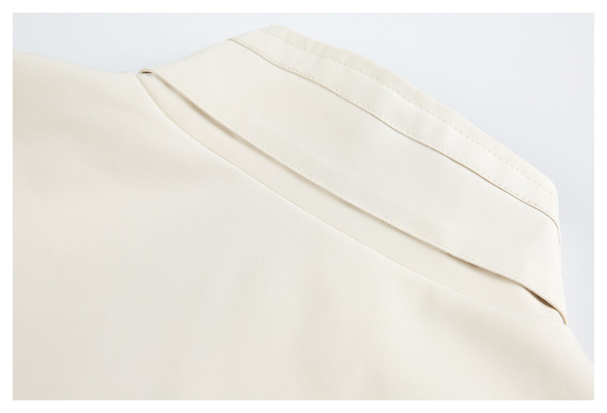 Close-up of an ivory garment panel with a folded, stitched edge and diagonal seam.