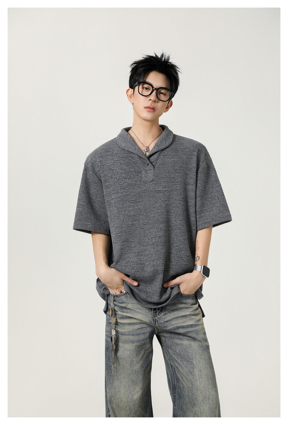 Model wearing a gray textured short-sleeve polo with a notched collar and faded wide-leg jeans.