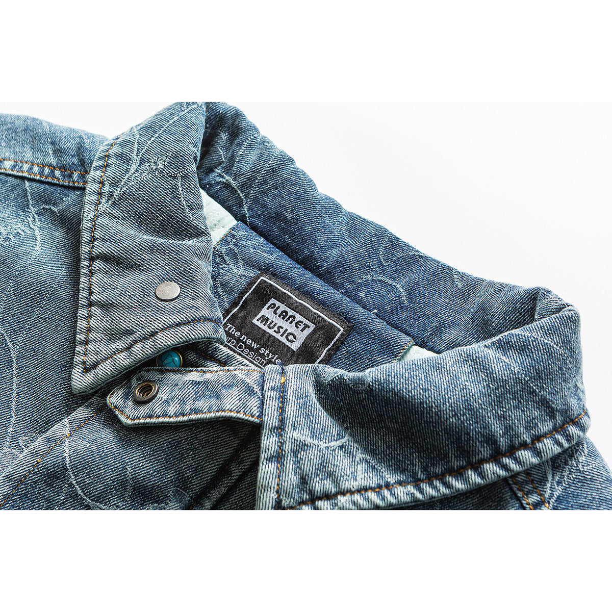 Close-up of a blue denim jacket collar, snap, and sewn-in English label.