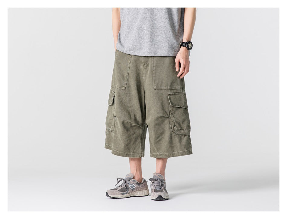 Person wearing green cargo shorts with a gray T-shirt, angled view showing the side flap pocket
