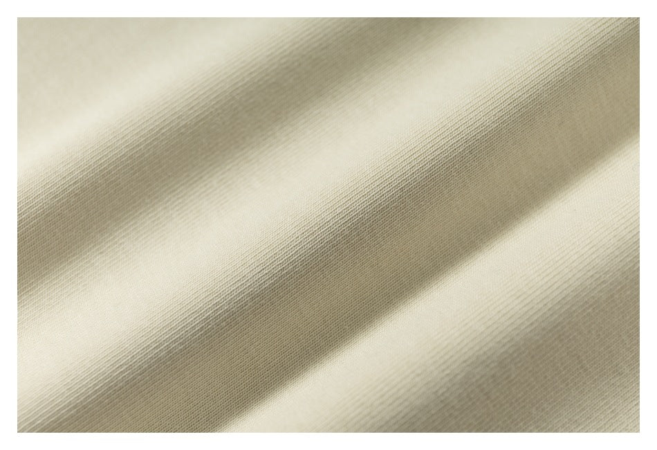 Close-up of ivory-colored fabric showing a fine, even knit texture.
