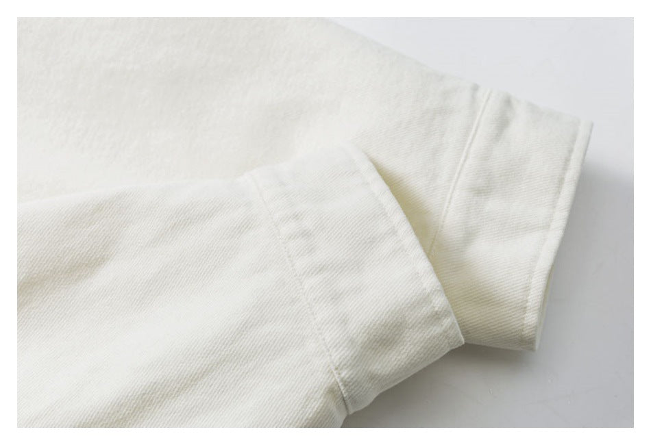 Close-up of overlapping off-white garment sleeves with stitched cuffs.