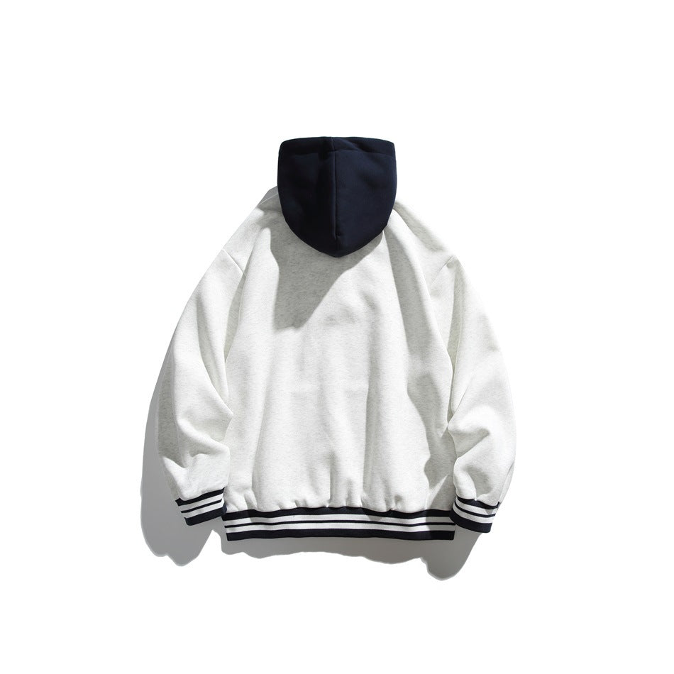 Back view of a white hoodie with a navy hood and black-and-white striped cuffs and hem.