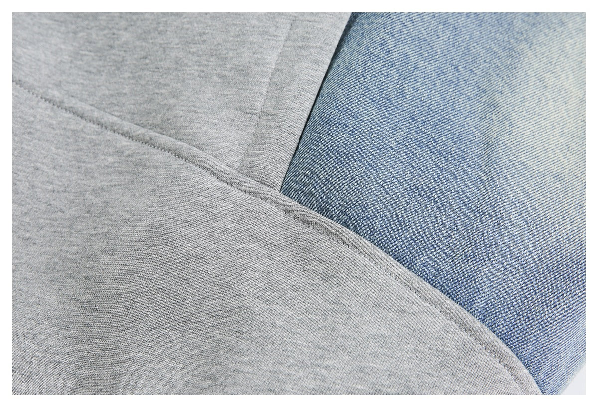Close-up of a gray knit jacket panel meeting a blue denim panel along a curved seam.
