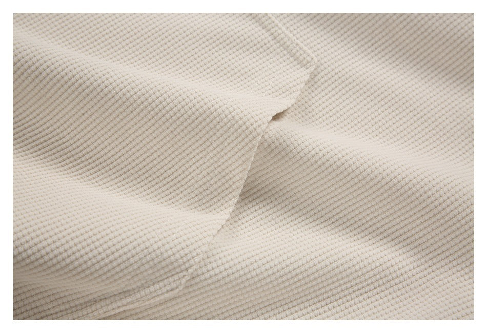 Close-up of a curved seam joining sections of cream textured fabric.