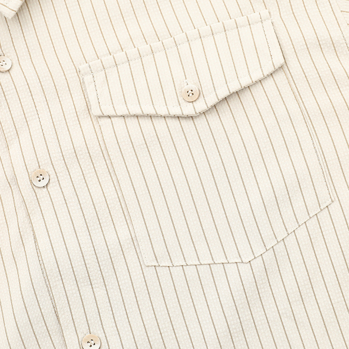 Close-up of the ivory striped shirt’s buttoned chest pocket and front placket.