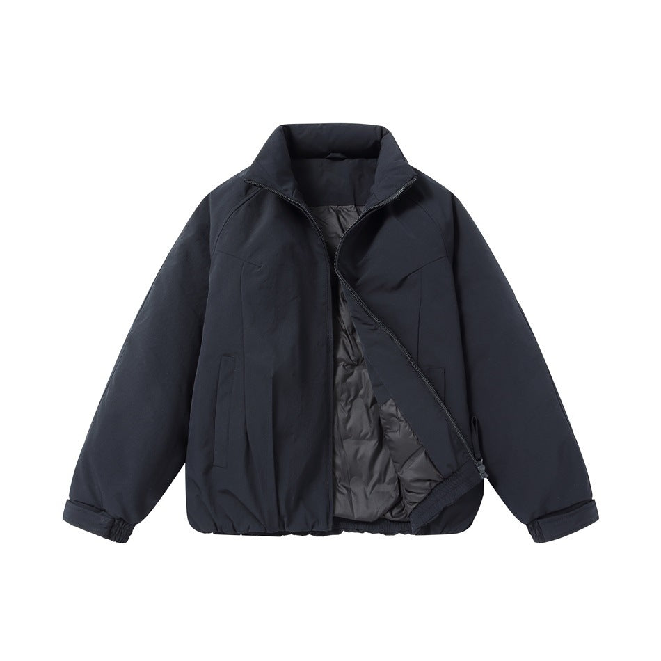 Navy jacket partly unzipped, showing dark gray quilted interior and elastic hem
