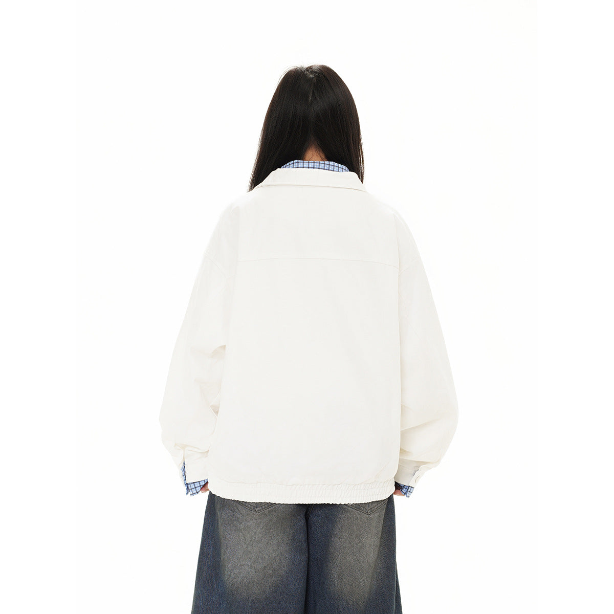 Back view of a model wearing a white oversized jacket with blue checked collar and cuffs.