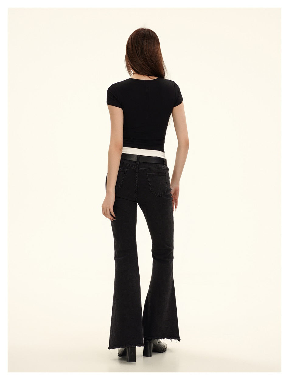 Back view of a model wearing a black short-sleeve top with a white hem band and black flared pants.