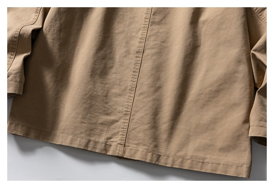 Close-up of the tan jacket's back panel, center seam, and lower hem.