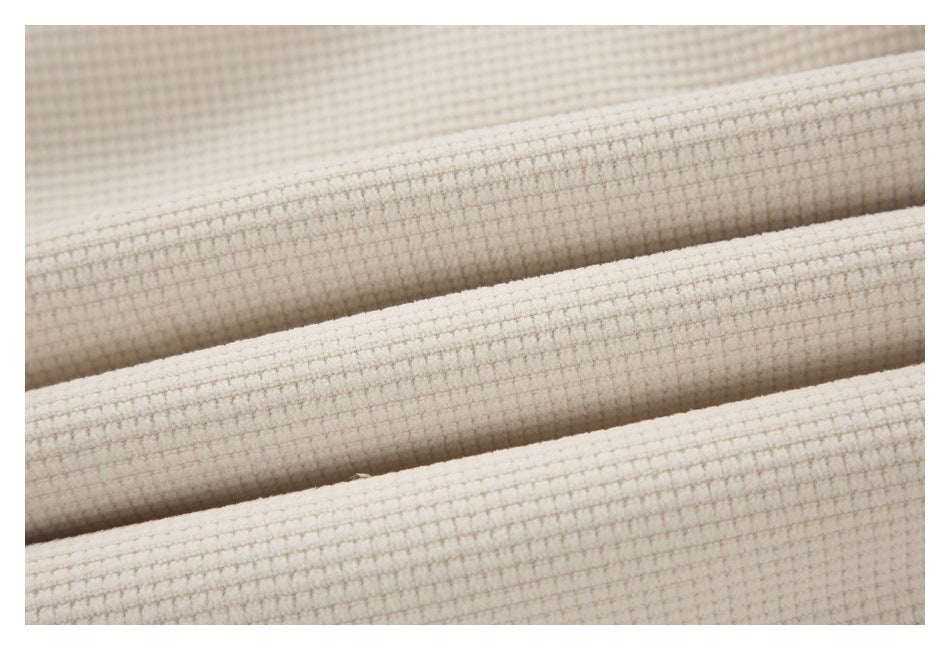 Close-up of cream fabric showing its raised waffle-knit texture.