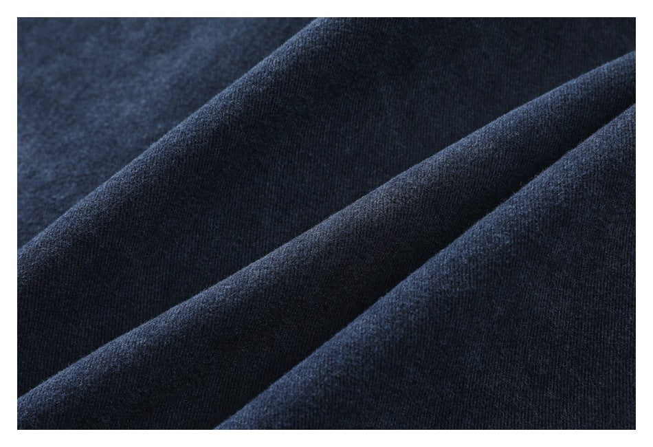 Extreme close-up of dark indigo fabric draped in folds, showing its fine surface texture.