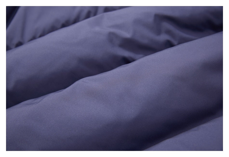 Close-up showing the slate-blue garment's padded panels and fine fabric texture.