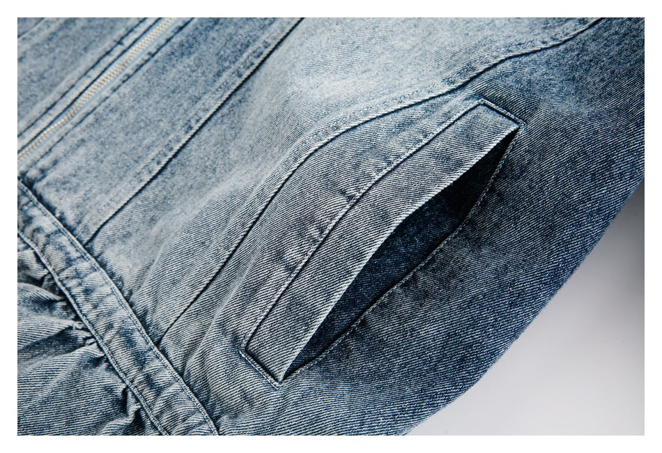 Close-up of a slanted pocket opening and stitched seams on faded blue denim.