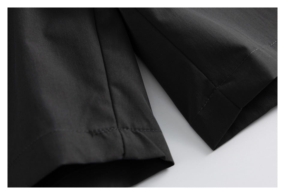 Close-up of the black pants legs and stitched hems.