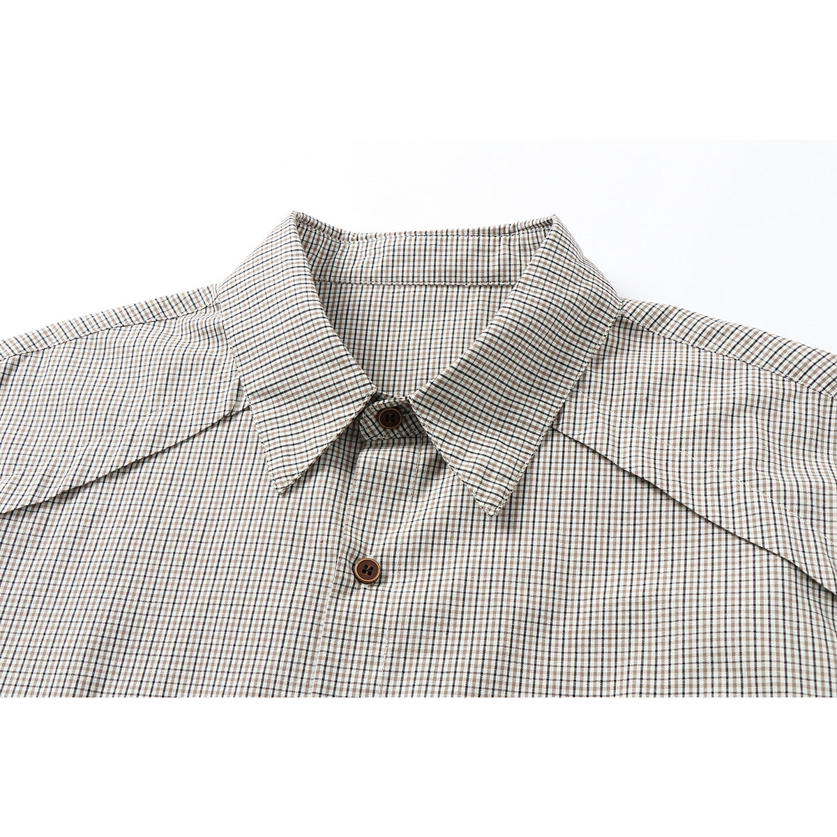 Close-up of a beige, brown, and black checked shirt collar and upper front with brown buttons.