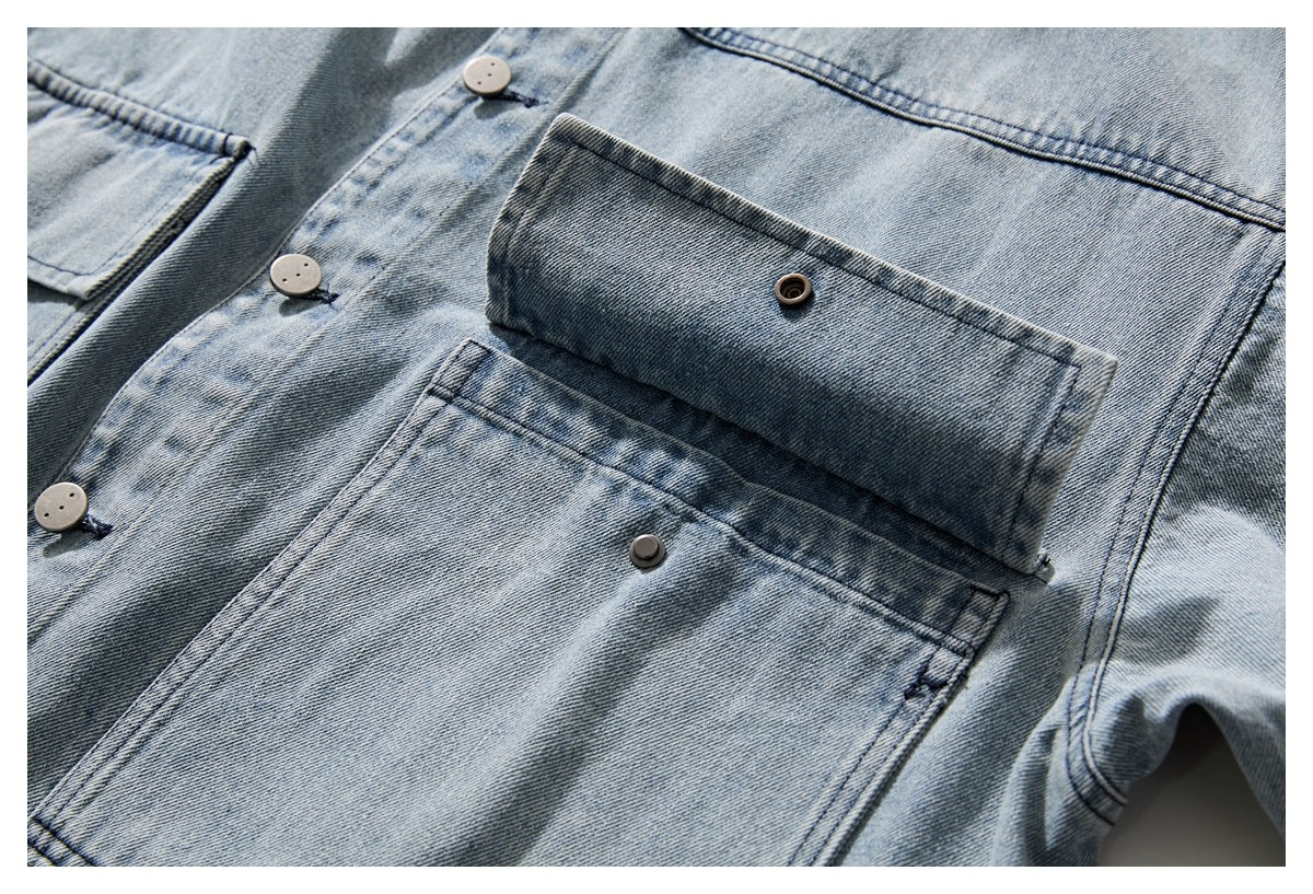 Close-up of a light blue washed denim jacket pocket with a buttoned flap and visible front buttons.