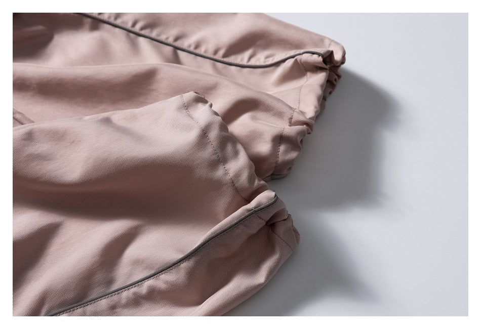 Close-up of the gathered ankle cuff and piped seam on the mauve pants.