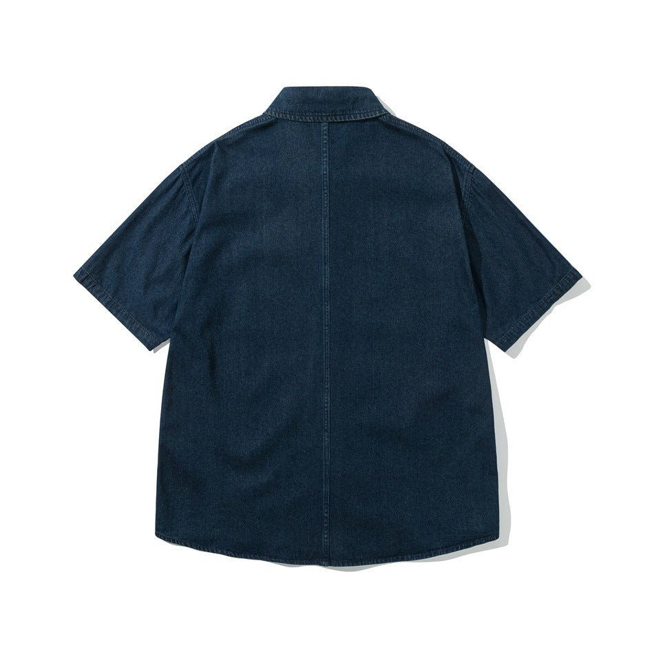 Back view of dark blue short-sleeve denim shirt with center back seam, flat lay