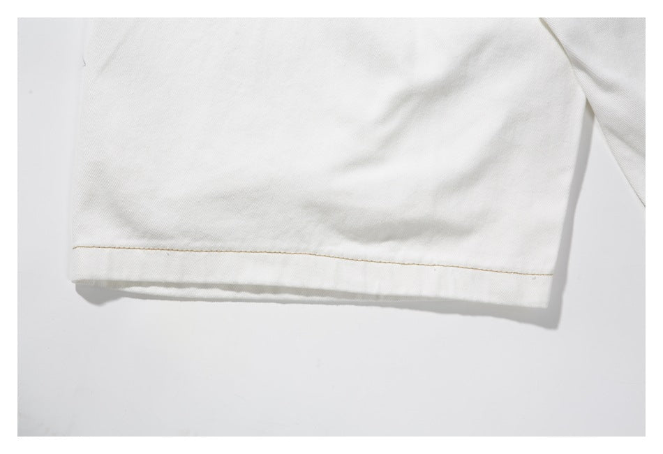 Close-up of the straight hem on a white trouser leg with tan stitching.