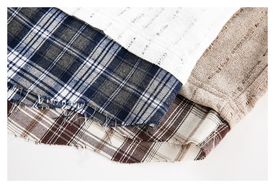 Close-up of layered fabric edges in white, beige, and navy-and-brown plaid.