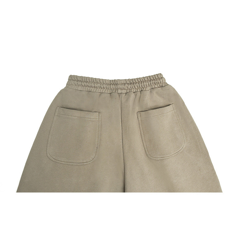 Upper back of taupe pants showing an elastic waistband and two patch pockets.