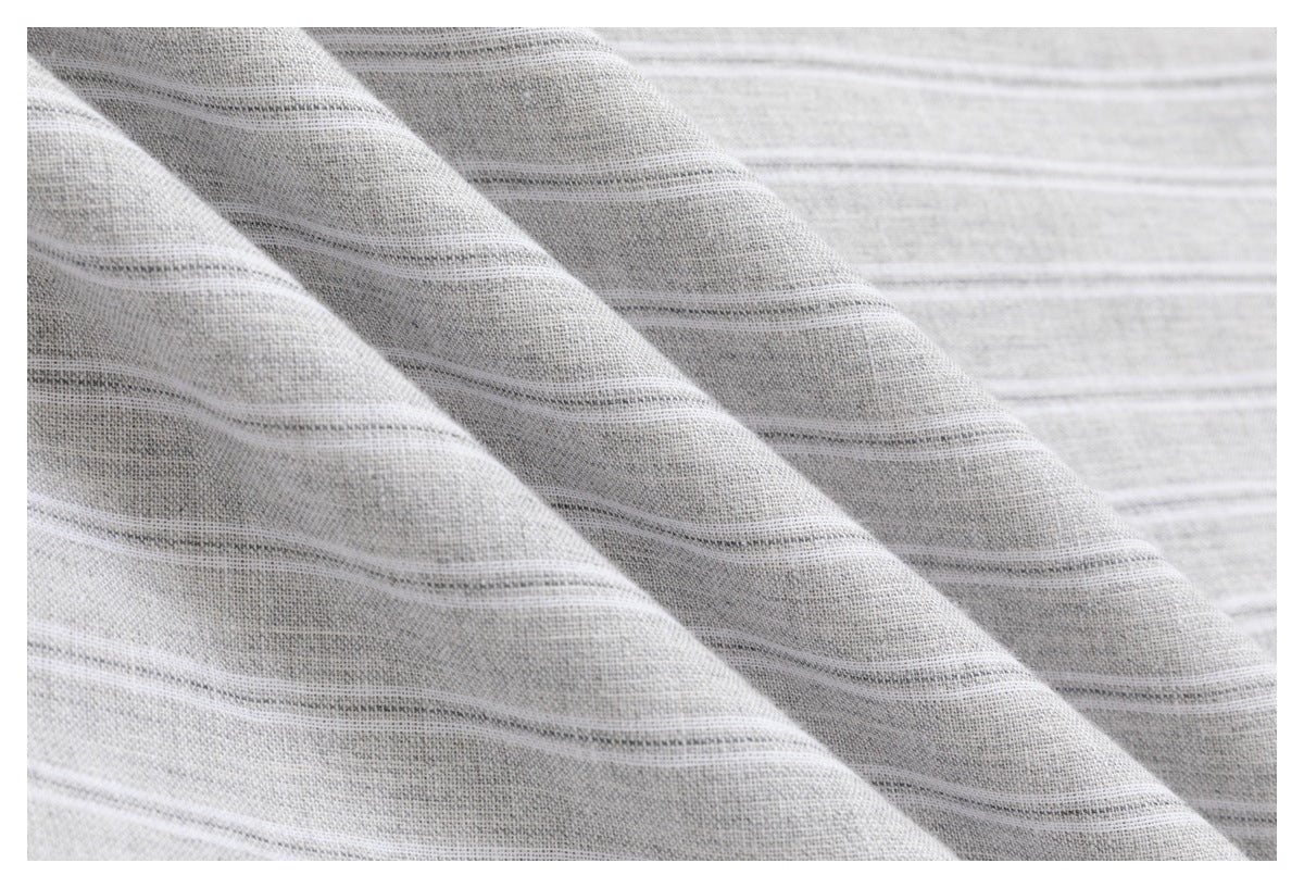 Close-up of light gray fabric with subtle white and darker horizontal stripes.