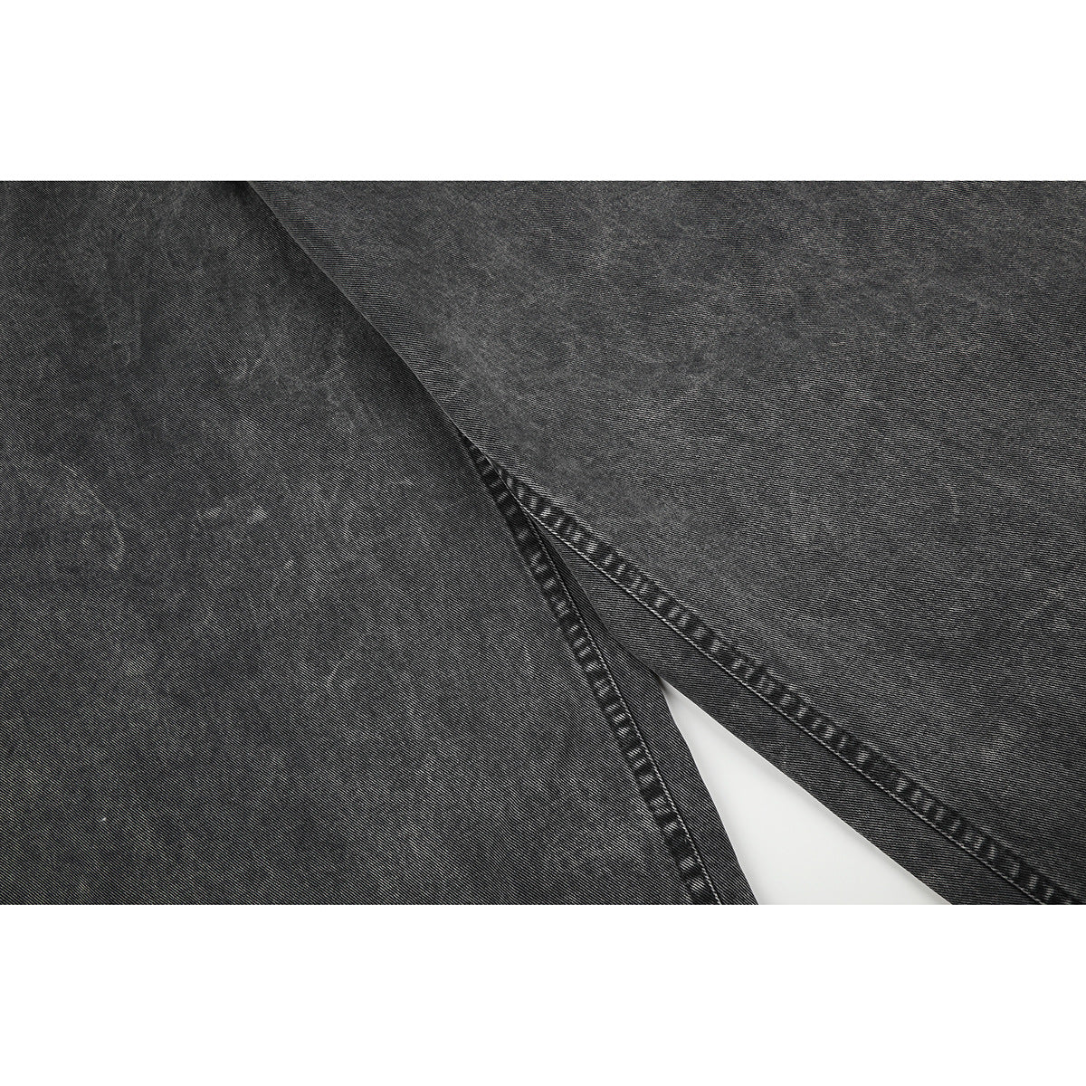 Close-up of charcoal-gray denim legs and stitched seams.