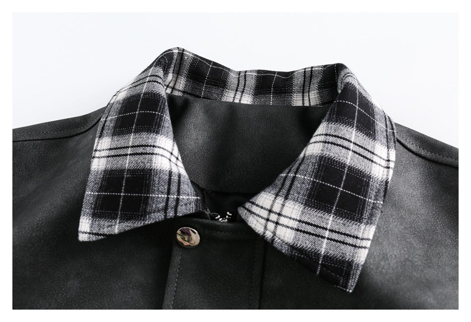 Close-up of a dark jacket with a black-and-white plaid collar and a metal snap on the front placket.