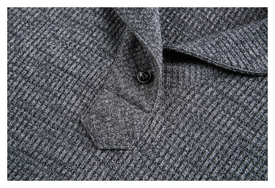 Close-up of the charcoal gray knit garment's collar, placket, and dark button.