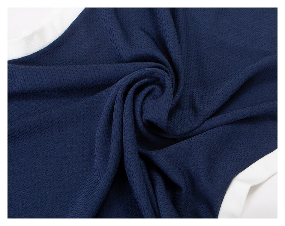 Close-up of navy textured fabric gathered into folds, with white trim visible at the edges.