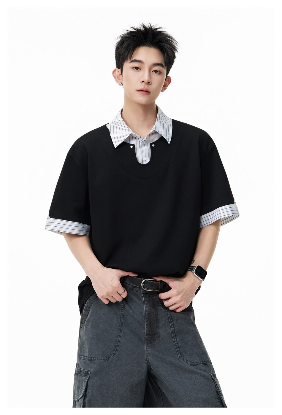 Close view of a model wearing a black oversized top with a striped collar and striped sleeve cuffs.