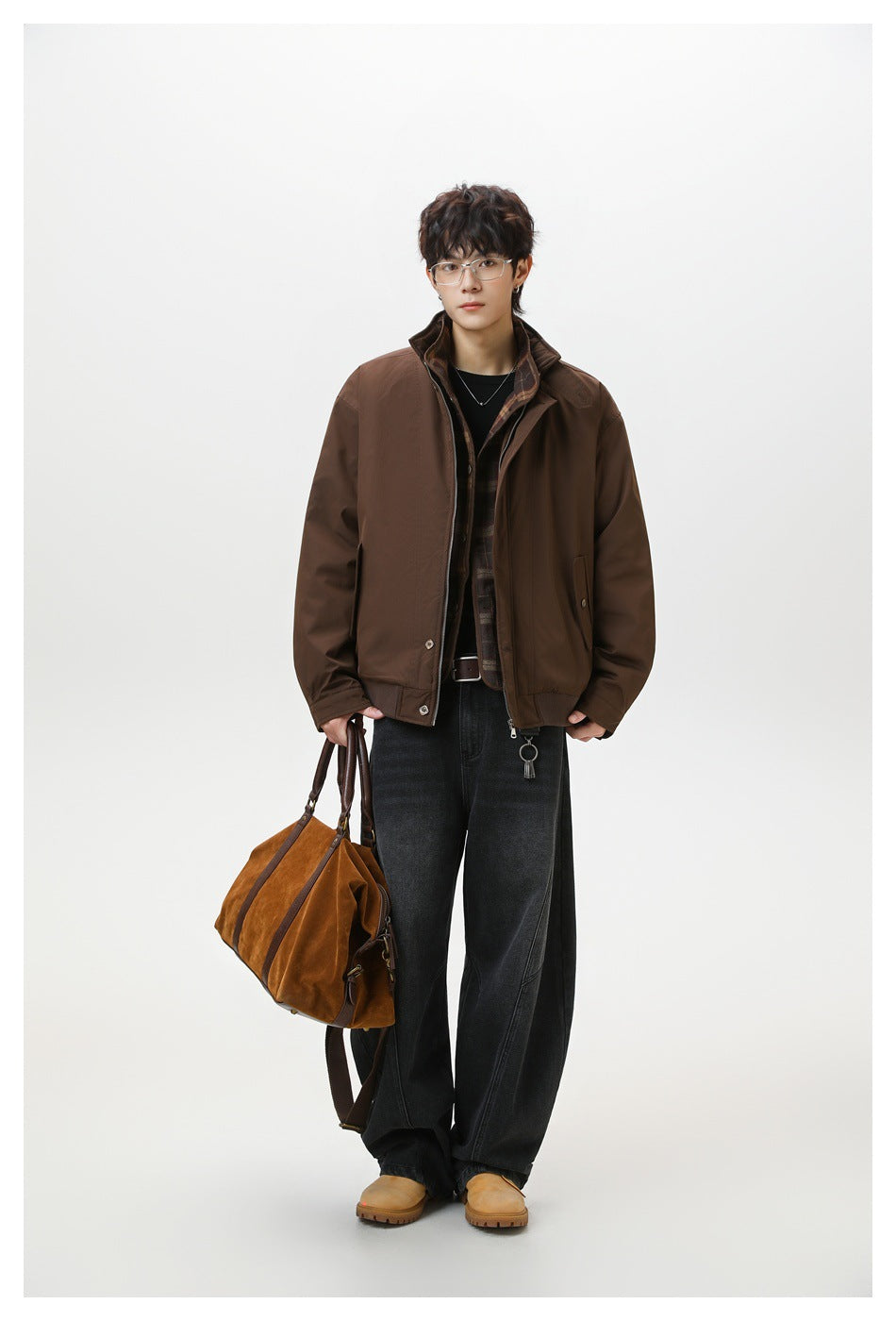 Model wearing a brown zip-front jacket with a plaid inner layer, carrying a tan bag.