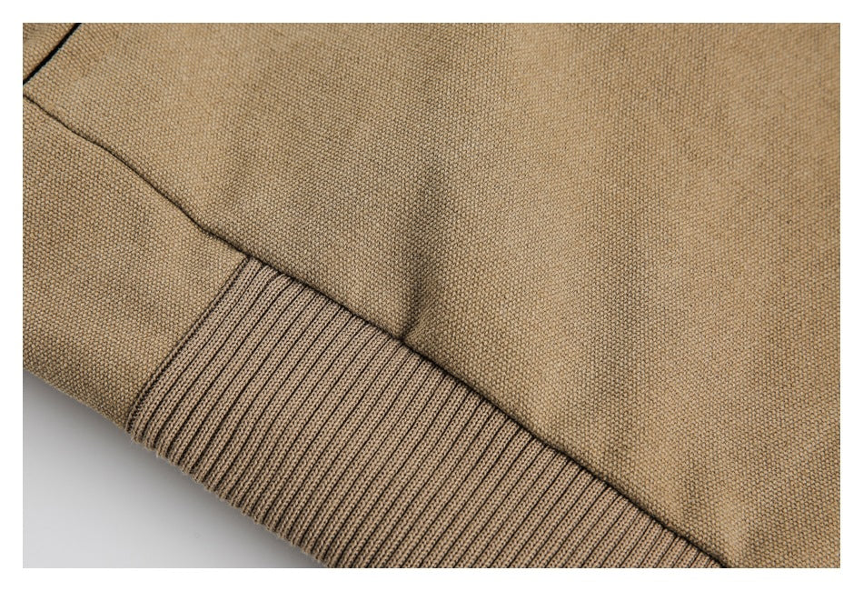 Close-up of a ribbed tan jacket hem and adjacent seam.