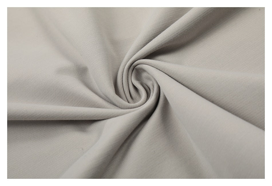 Close-up of light gray fabric gathered into a spiral, showing its fine texture.