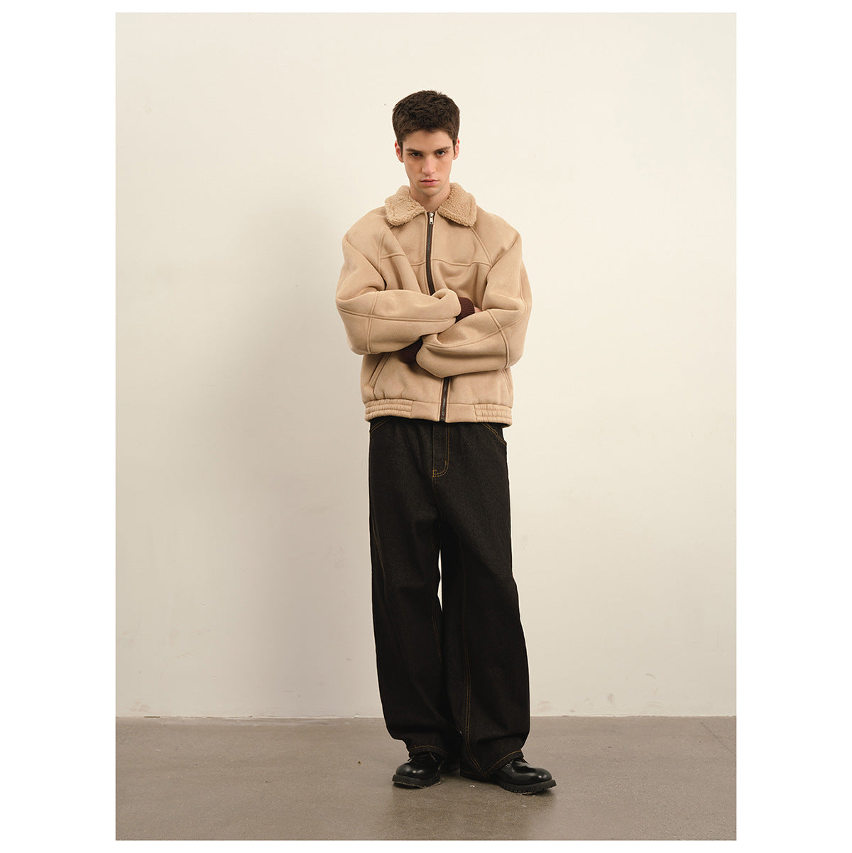 Model wearing a beige zip-front jacket with a plush collar and wide-leg black trousers.