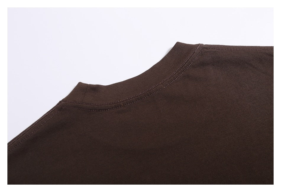 Close-up of the ribbed crew neckline and shoulder seam on a dark brown garment.