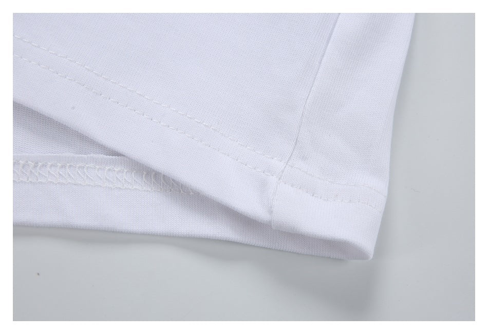 Close-up of a white garment's stitched hem and overlocked seam.