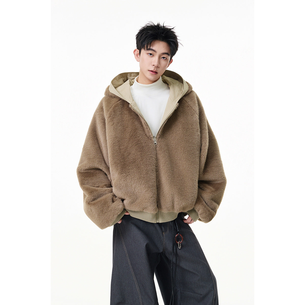 Model wearing a taupe plush hooded jacket with a beige hood lining, front zipper, and ribbed hem.