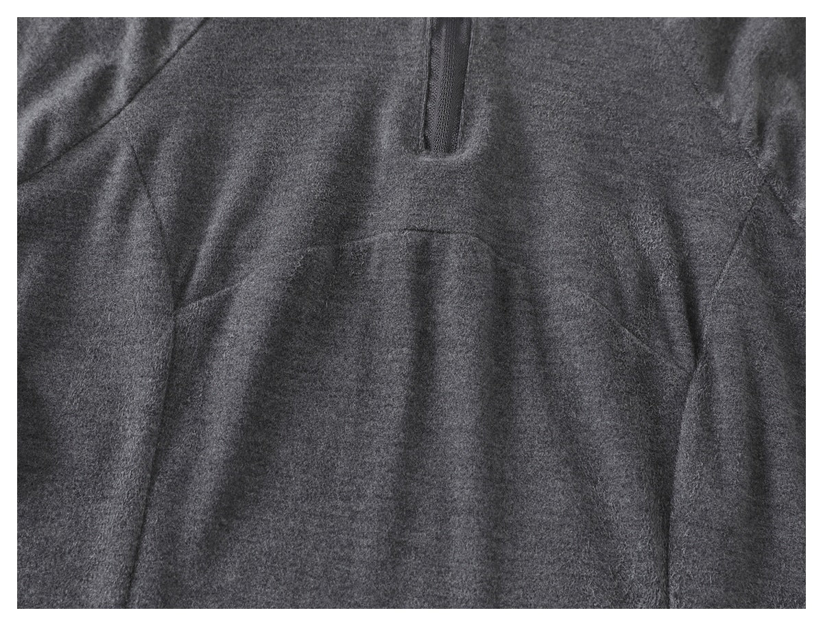 Close-up of the charcoal gray hoodie front, showing the short zipper and curved pocket seams.