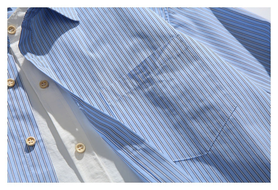 Close-up of a light blue striped shirt showing its chest pocket, white button placket, and tan buttons.