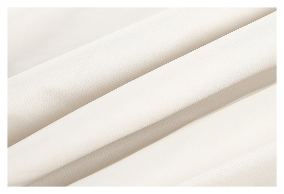 Close-up of folded off-white fabric with a subtle fine grid pattern.