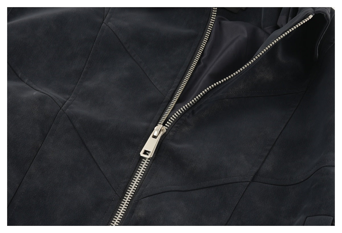 Close-up of a dark jacket with a silver front zipper, diagonal panel seams and smooth dark lining.