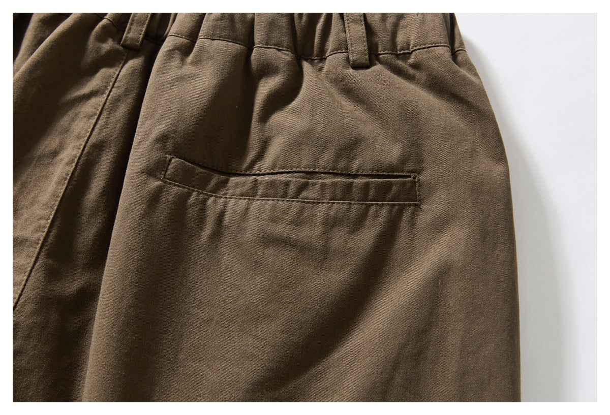 Close-up of a welt pocket on the back of brown trousers.