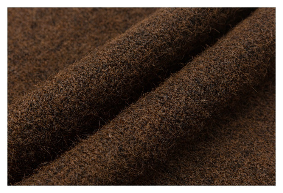 Macro view of brown fuzzy knit fabric folded into raised ridges.
