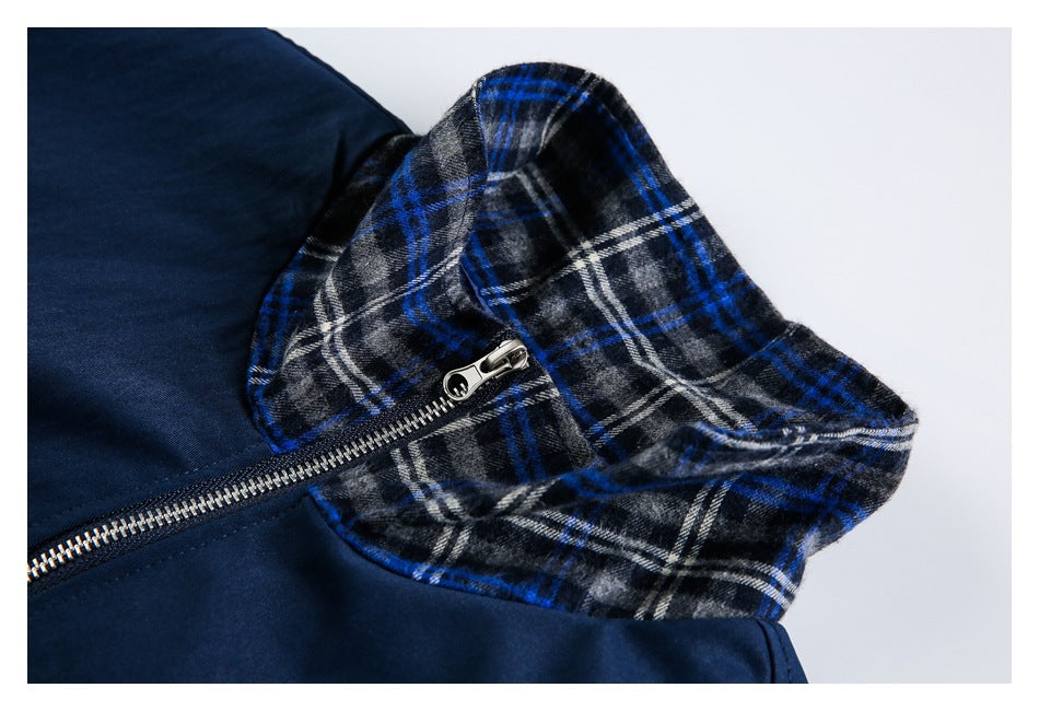 Close-up of the jacket's blue, black and white plaid collar and metal front zipper.