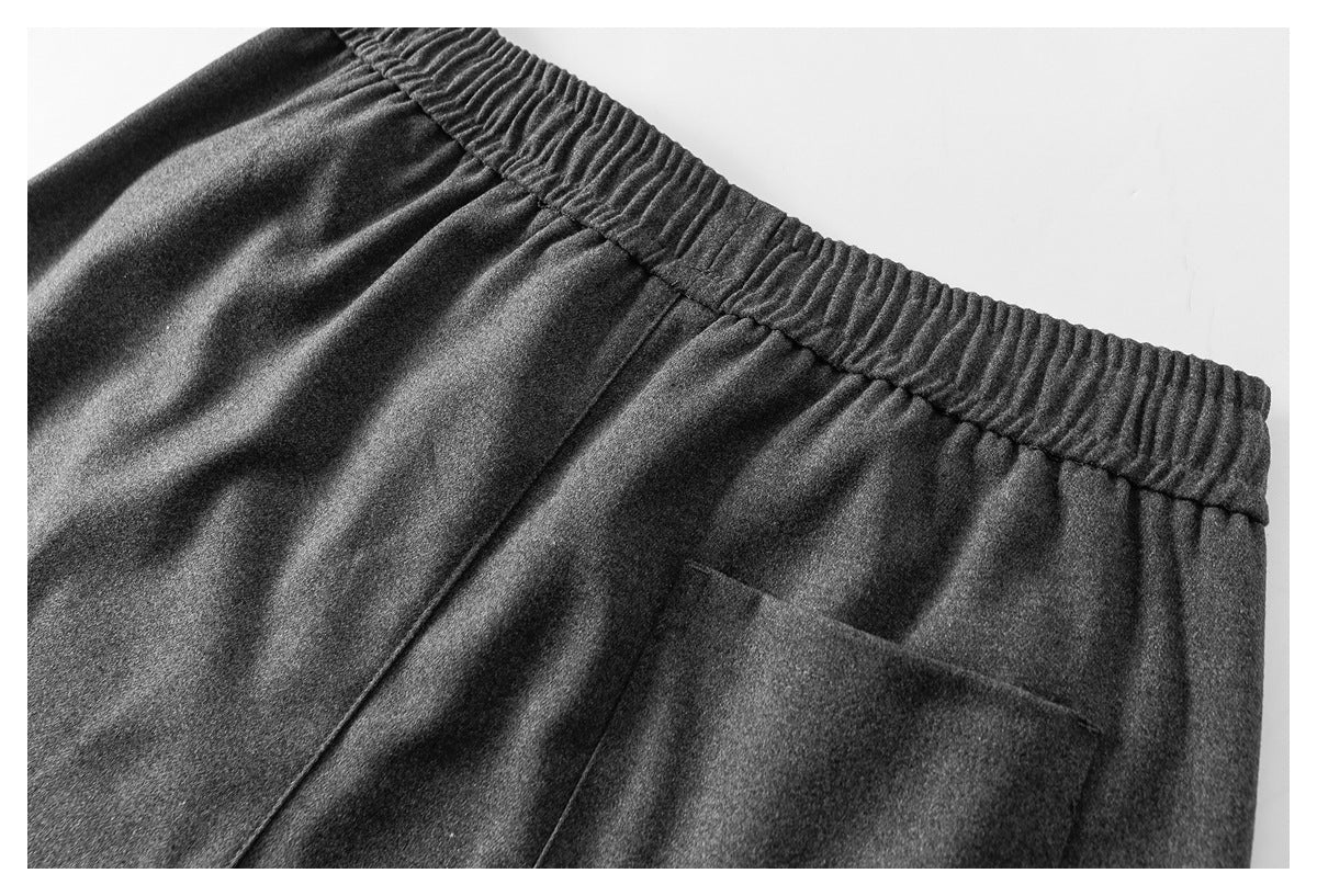 Close-up of the back of charcoal-gray pants with an elastic waistband and a rectangular pocket.