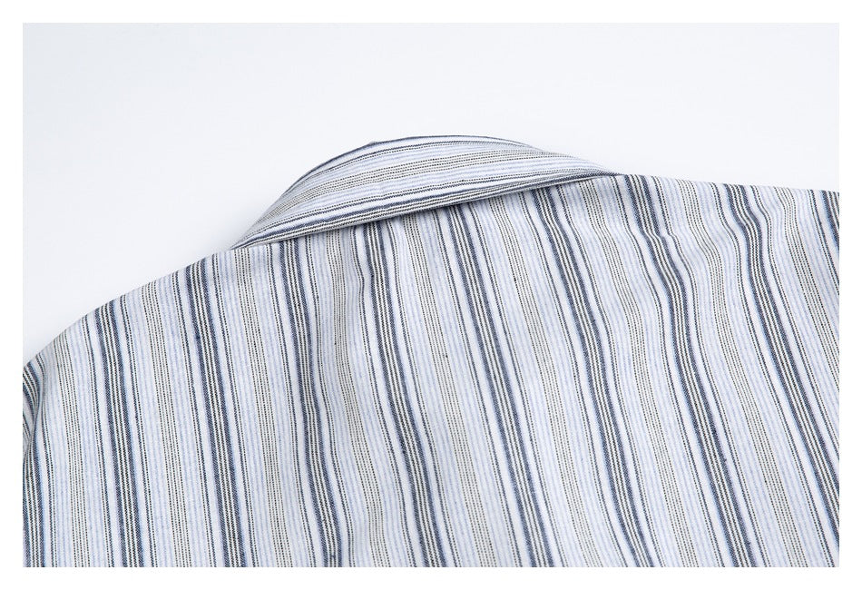 Close-up of a white shirt's striped shoulder and folded collar against a plain white background.